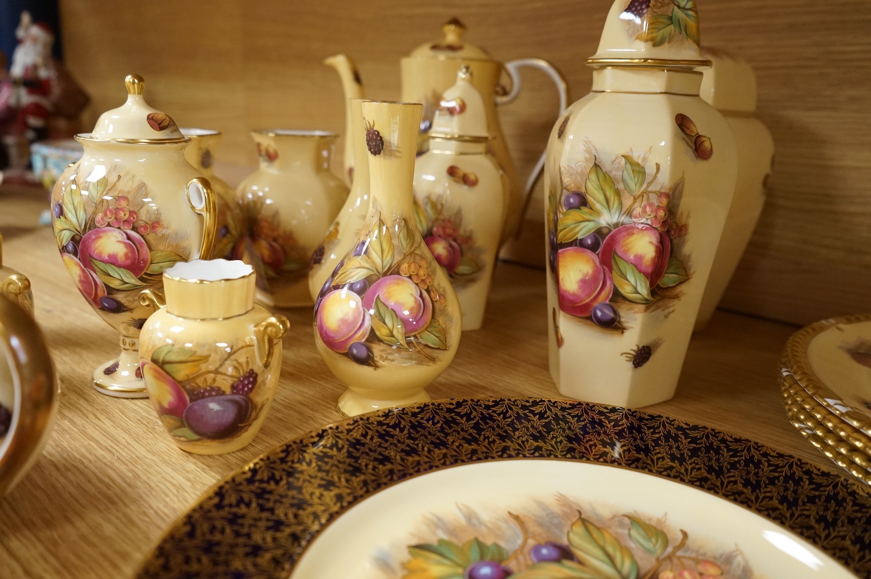 A collection of Aynsley ‘Orchard Gold’ fruit-painted tea/dinner wares and vases, largely signed by D Jones, largest 26cm in diameter
